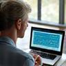 Person using a laptop with graphs, implying financial planning and peace of mind.